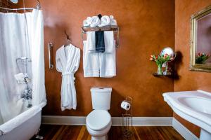 a bathroom with a toilet and a sink and a tub at Grand Highland Hotel in Prescott