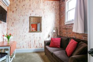 a living room with a couch and a brick wall at Grand Highland Hotel in Prescott