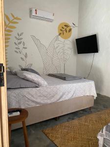 a bedroom with a bed with a mural on the wall at Recanto da Alice in Trancoso