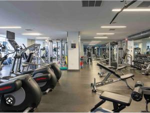 a gym with a lot of treadmills and machines at Stylish 2 Bedrooms Condo w/ awesome View & Parking in Toronto