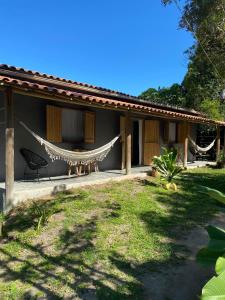 a house with a hammock in front of it at Recanto da Alice in Trancoso