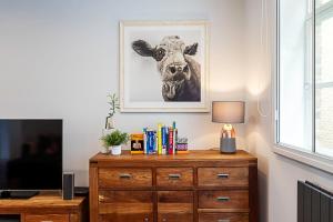 a room with a dresser and a picture of a cow at Blackfriars Printhouse Retreat in London