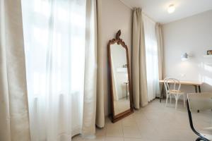 a mirror in a room with curtains and a table at Zaunkönig Apartments in Baden-Baden
