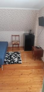 uma sala de estar com um sofá e uma televisão em Гостевой дом Анастасия em Sukhumi