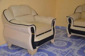 two white chairs are sitting in a room at EDISON CITY PALACE GUEST HOME in Bertoua