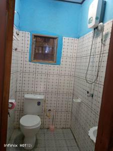 a bathroom with a toilet and a window and a sink at EDISON CITY PALACE GUEST HOME in Bertoua