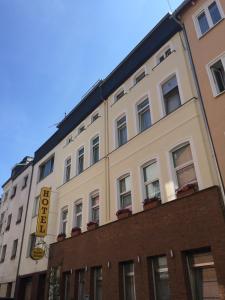 un gran edificio blanco con un cartel. en Hotel im Kupferkessel en Colonia
