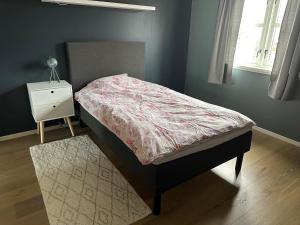 łóżko w sypialni z szafką nocną i łóżkiem o wymiarach sześciu w obiekcie Stor villa sentralt på Leknes w mieście Leknes