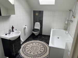 a bathroom with a sink and a toilet and a tub at Stor villa sentralt på Leknes in Leknes