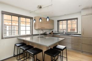 a kitchen with a large island with black bar stools at Alpenblick 10, Three level Townhome, Two Block From the Gondola in Aspen