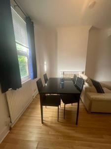 a living room with a table and a couch at 3 Bedroom House in Dartford in Kent