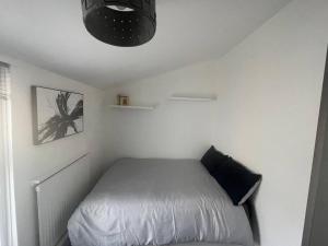 a bedroom with a bed in a white room at 3 Bedroom House in Dartford in Kent