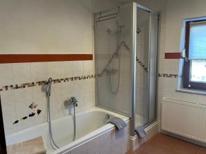 Das Bad ist mit einer Dusche und einer Badewanne ausgestattet. in der Unterkunft Haus Amalie in Söll