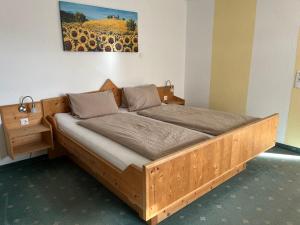 ein Holzbett in einem Zimmer mit einem Bild an der Wand in der Unterkunft Haus Amalie in Söll