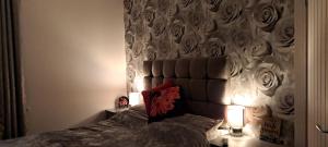a bedroom with a bed with a headboard and two lamps at Cosy Double Room in Harrogate