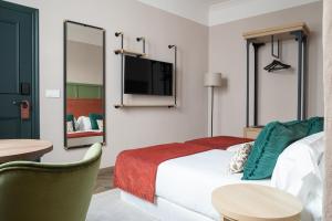 um quarto de hotel com uma cama e uma televisão em The Honest Hotel em Sevilha