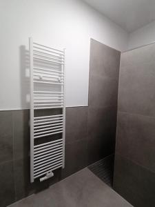 a bathroom with a shower with a mirror and brown tiles at estrella24 LIVING ROOMS Tokio in Herne