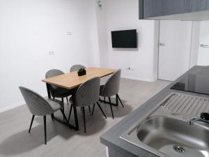 een keuken met een tafel en stoelen en een wastafel bij estrella24 LIVING ROOMS Tokio in Herne