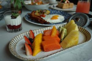 a plate of fruit and eggs on a table at The St. Regis Kanai Resort, Riviera Maya in Playa del Carmen