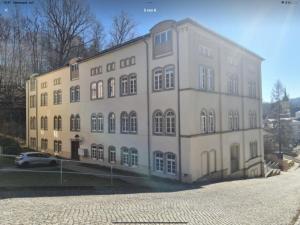 een groot gebouw met een auto voor de deur bij Elbenland Apartments Sächsische Schweiz in Sebnitz