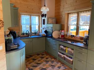 a kitchen with green cabinets and counters and windows at Chalet Alma in Haus im Ennstal