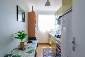 eine Küche mit einem Tisch und einer Topfpflanze darauf in der Unterkunft Perle Parisienne, Vue Captivante in Saint-Ouen