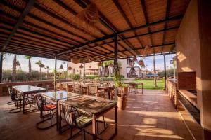 una zona de comedor al aire libre con mesas y sillas en Al Destino Villa Riad Spa Luxury Marrakech, en Marrakech