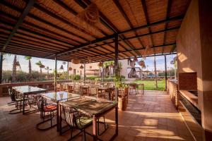 an outdoor dining area with tables and chairs at Al Destino Villa Riad Spa Luxury Marrakech in Marrakech