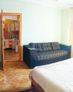 ein Wohnzimmer mit einem blauen Sofa in einem Zimmer in der Unterkunft Затишна квартира в центрі Калуша in Kalush