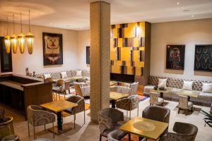 un vestíbulo con mesas, sillas y un piano en Al Destino Villa Riad Spa Luxury Marrakech, en Marrakech
