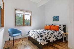 a bedroom with a black and white bed and a blue chair at Stone Ledge in Margaretville