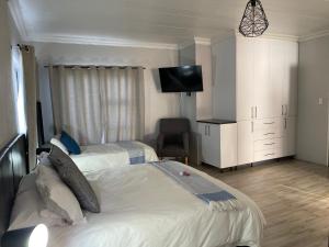 a bedroom with two beds and a flat screen tv at The Chameleon in Centurion