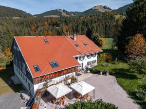 eine Luftansicht eines Hauses mit orangefarbenem Dach in der Unterkunft Am Hof Jungholz in Jungholz