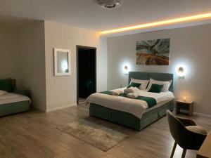 um quarto com uma cama grande e uma cadeira em Vila Diamond Lux&Spa em Sovata