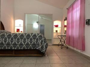阿卡普爾科的住宿－Casa Acapulco Bello，一间卧室配有一张床和粉红色窗帘