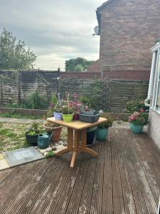 a wooden table with potted plants on a patio at LN host in Rockingham