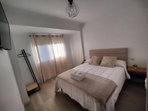 a bedroom with a large bed with white sheets at O Lar da Muralla in Lugo