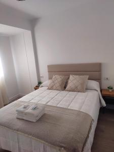 a large bed with two trays on top of it at O Lar da Muralla in Lugo +1 photo