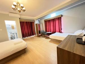 una camera d'albergo con due letti e un lampadario a braccio di Boudha Apart Hotel a Kathmandu