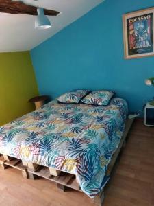 uma cama num quarto com uma parede azul em Maison familiale Nantes Sud em Bouguenais