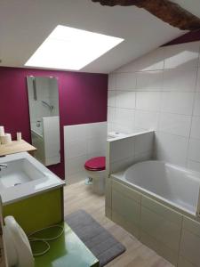 uma casa de banho com uma banheira, um WC e um lavatório. em Maison familiale Nantes Sud em Bouguenais