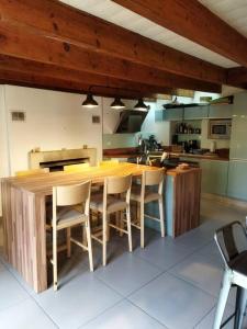 uma cozinha com uma grande mesa de madeira e cadeiras em Maison familiale Nantes Sud em Bouguenais
