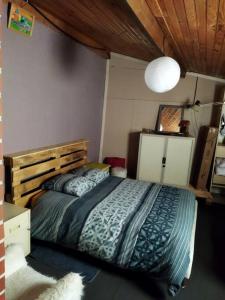um quarto com uma cama grande e uma cabeceira em madeira em Maison familiale Nantes Sud em Bouguenais