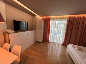 a hotel room with a television and a bed and a table at Alb's Apartment 2 in Golem