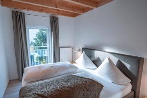 Schlafzimmer mit einem Bett und einem großen Fenster in der Unterkunft Am Hof Jungholz in Jungholz