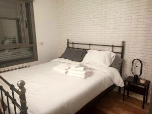 a bed with white sheets and towels on it at Precioso apartamento céntrico en Madrid con posibilidad de Parking in Madrid
