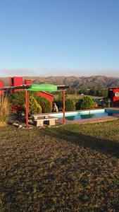 a swimming pool in a yard with a house at cabañas altos de giardino in Villa Giardino