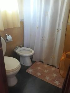 a bathroom with a toilet and a shower curtain at cabañas altos de giardino in Villa Giardino