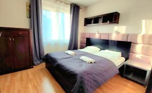 a bedroom with a bed with two towels on it at Morza Szum Jantar TriApart in Jantar