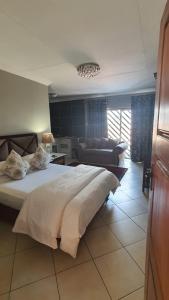 a bedroom with a large bed and a couch at Opikopi Guest House in Pretoria